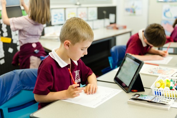 student at desk with ipad